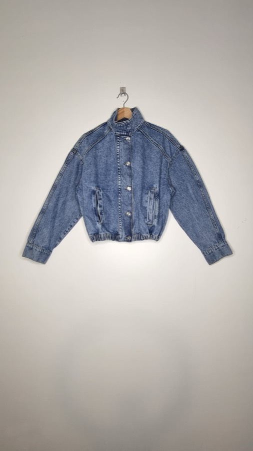 Correctly shot denim jacket on a wooden hanger against a clean white background